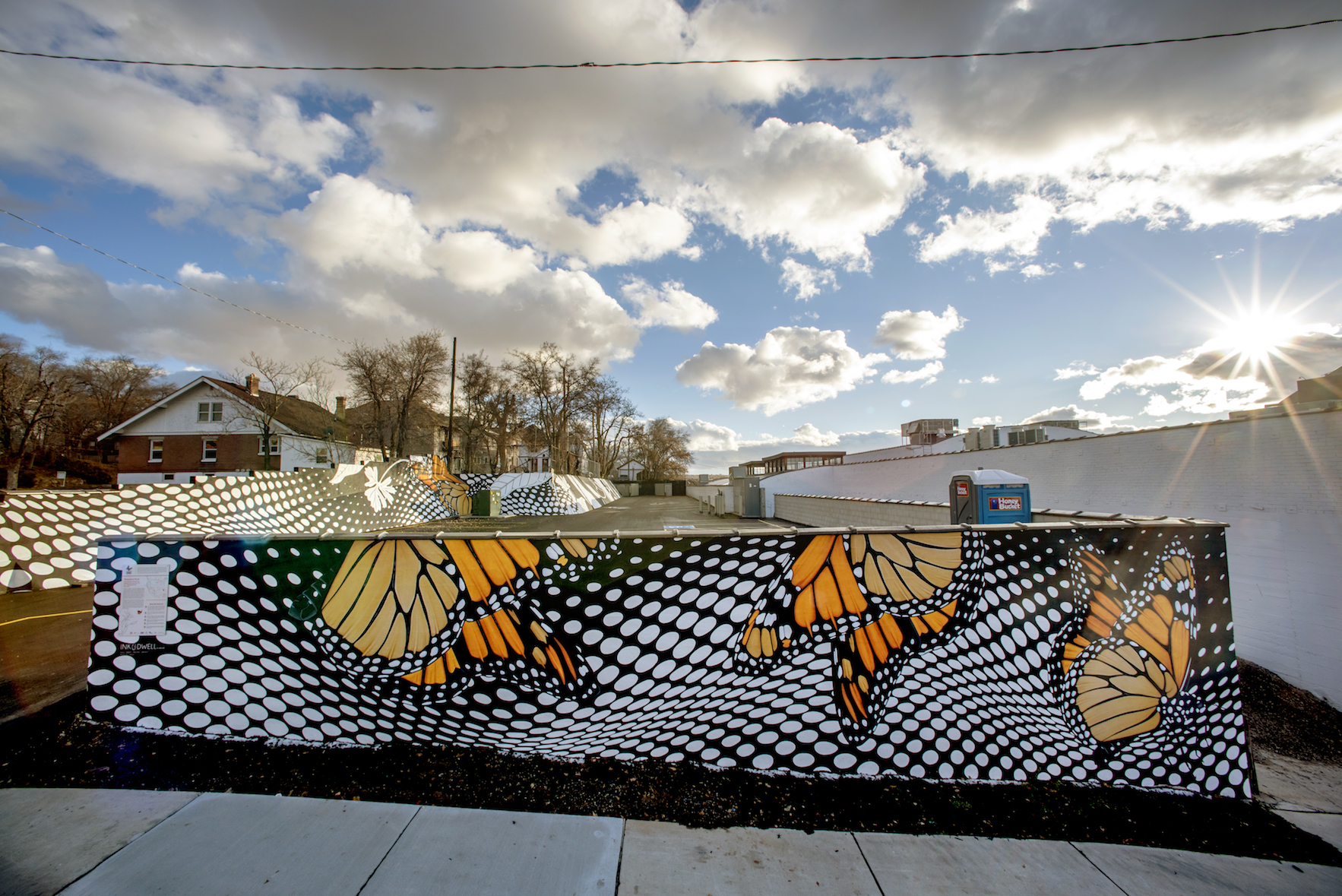 Dramatic black-and-white patterns contrast the bold orange-and-black wings of monarch butterflies in the Monarch in Moda mural in Ogden, Utah.