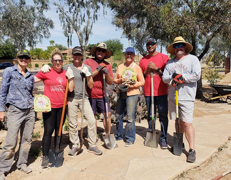 Group of people standing with shovels at the park