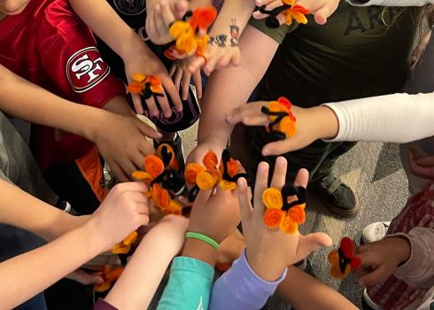 Group of students with pipe cleaner monarch rings on hands