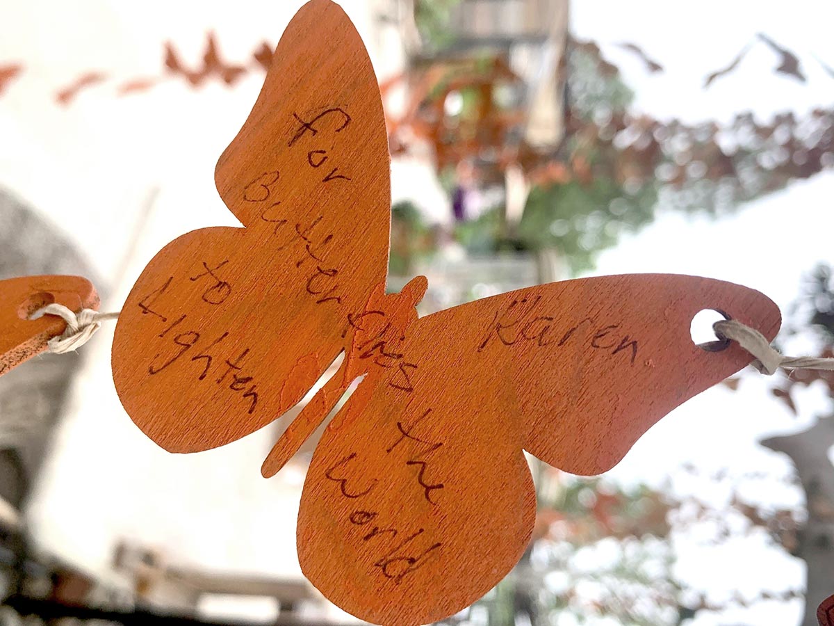 Wooden butterfly with wish written: For butterflies to light up the world 